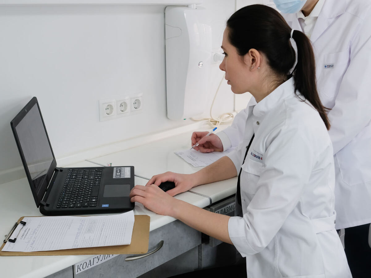 A doctor reviewing a healthcare dashboard on a laptop