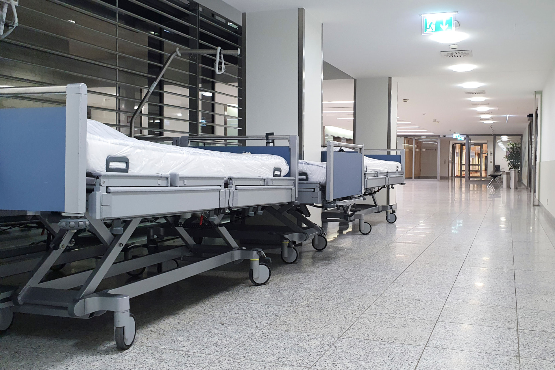 Hospital corridor with beds and nursing station in natural light